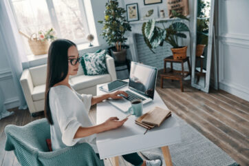 working from home. top view of beautiful young woman working using laptop while sitting in home office